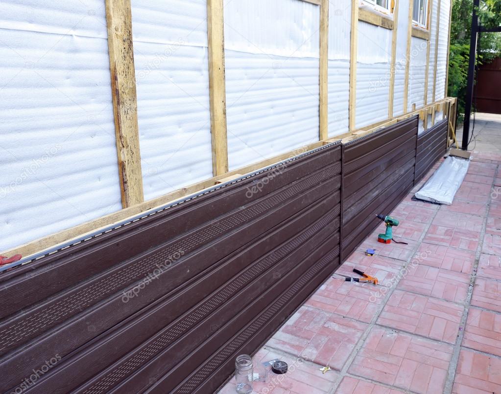 Installation of brown plastic siding on the facade — Stock Photo