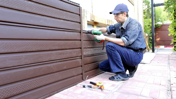 Arbeiter montiert Kunststoff-Abstellgleis an Hausfassade — Stockfoto