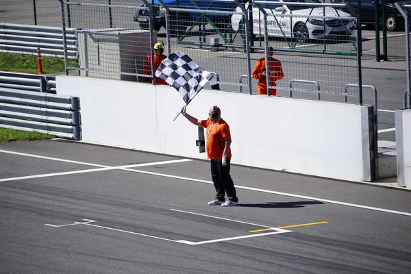 A man with a checkered flag on the race bikes track — Stock Photo, Image