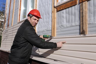 Bir işçi cephe dış cephe kaplaması panelleri bej yükler
