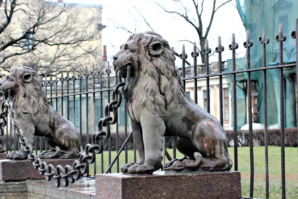 Několik soch bronzových lvů podél plotu — Stock fotografie