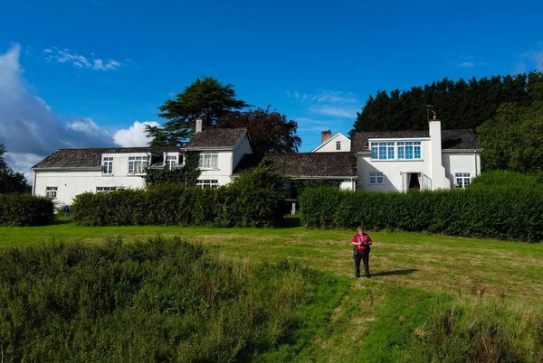 Ein Mann Steuert Eine Drohne Vor Einem Bauernhaus Devon Countryside lizenzfreie Stockfotos