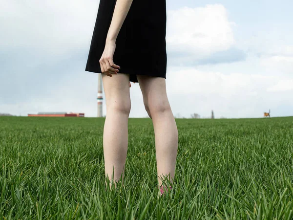 White standing person legs on green field