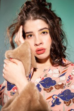 Yeşil üzerinde izole edilmiş kıvırcık saçlı genç kızın portresi.