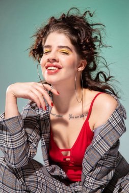 Kırmızılı, yeşil elbiseli beyaz Avrupalı manken.