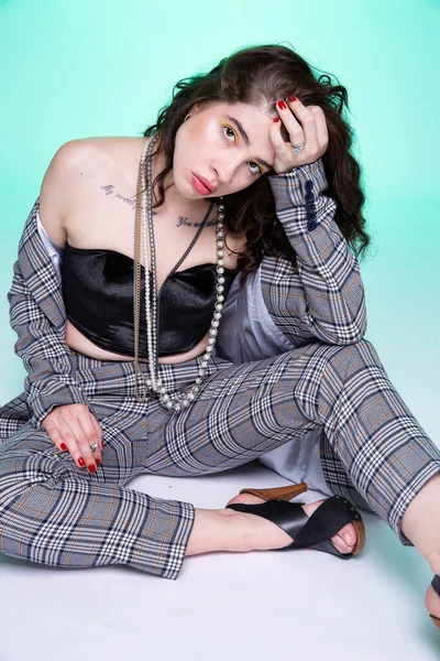 Avrupalı kız yeşil zeminde tek başına oturuyor.