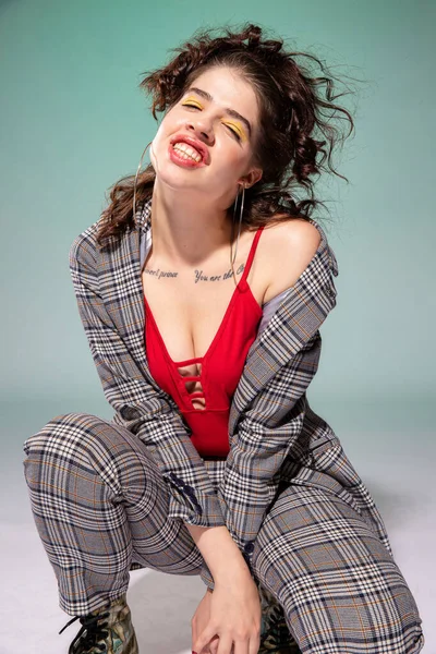 Kırmızılı, yeşil elbiseli beyaz Avrupalı manken.