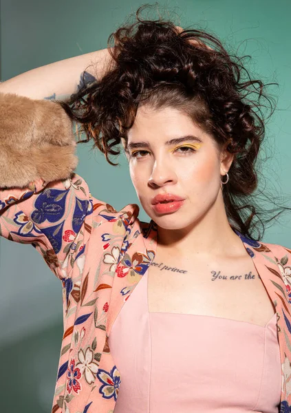 Genç Avrupalı kadın, yeşil üzerinde izole edilmiş yüz portresinin yanında eli ile