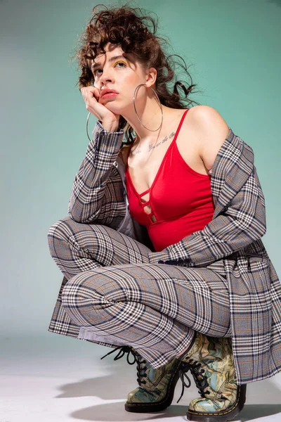 Düşünceli beyaz kız, kıvırcık saçlı yeşil üzerinde izole edilmiş.