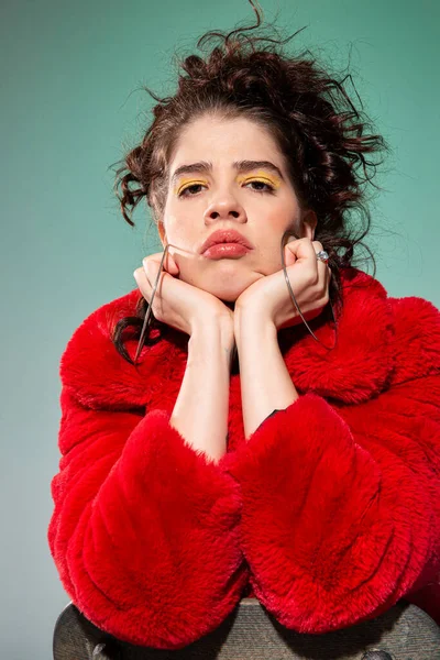 Kırmızı portredeki kıvırcık saçlı kız yeşile izole edilmiş.