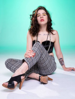 Koyu kıvırcık saçlı, yeşil renkli beyaz bir model.