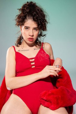 Yeşil üzerinde izole edilmiş sigara taşıyan beyaz kız modeli.