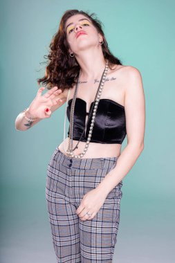 Kafası geriye atılmış bir kız yeşilde tek başına duruyor.