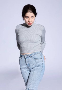 Gri kazaklı beyaz kız Gri üzerine izole edilmiş