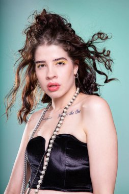 Yeşil üzerine izole edilmiş uçan saçlı genç beyaz kadın portresi.