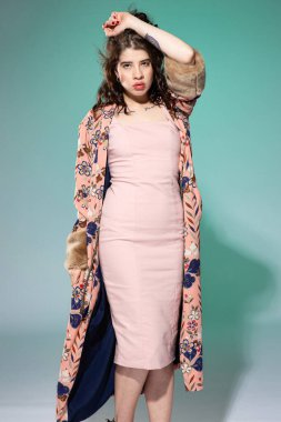 Pembe elbiseli genç bir kadın. Yüzüne yakın bir yerde. Yeşilde izole edilmiş.