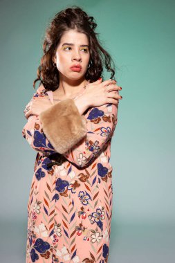 Pembe elbiseli, yeşil dudaklı genç bir kadın.