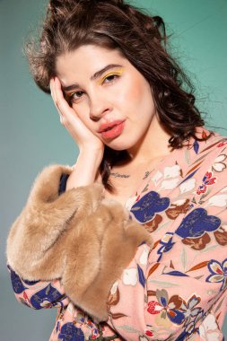 Pembe elbiseli, yeşil dudaklı genç bir kadın.