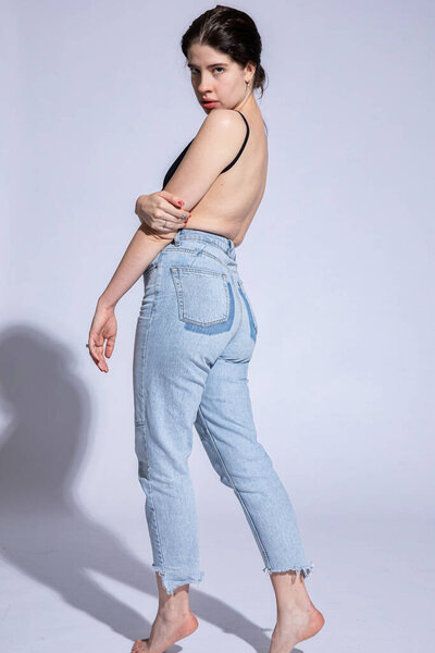 Young woman in jeans isolated on pink