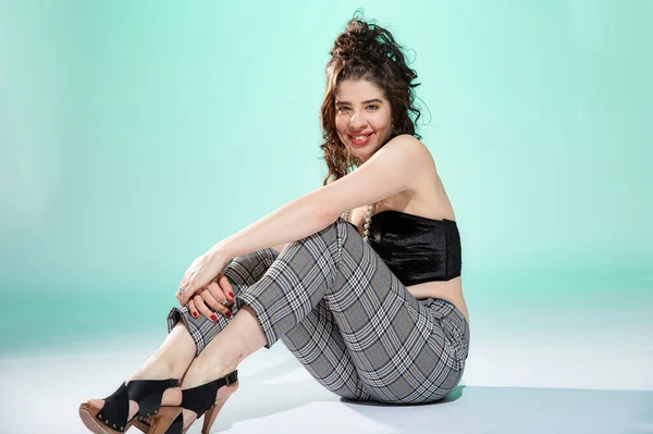 Girl sits on the floor isolated on green