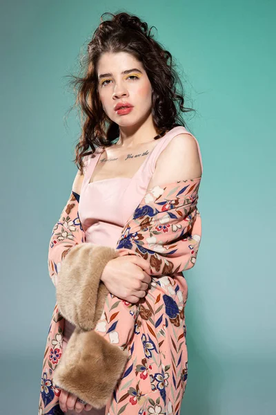 Pembe elbiseli genç kadın yeşilde izole edilmiş.