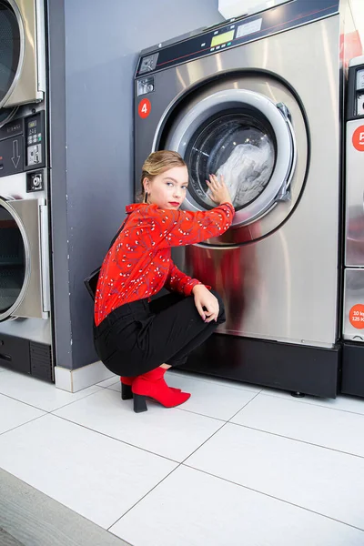 Çamaşır makinesi olan siyah pantolonlu kız model.