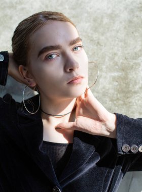 Sarışın, elleri yüzünün yanında olan Avrupalı bir kız.