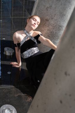 Genç model kızın yerde otururken yüksek açılı görüntüsü.