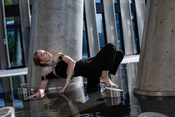 Beton sütunların arasında yere değen genç bir model kız.