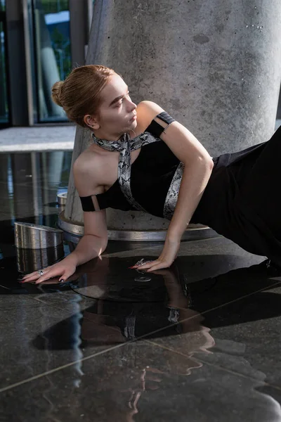 Beton sütunların arasında yere değen genç bir model kız.