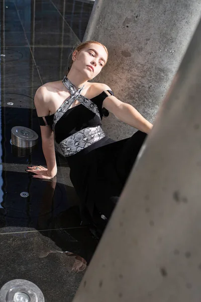 Genç model kızın yerde otururken yüksek açılı görüntüsü.