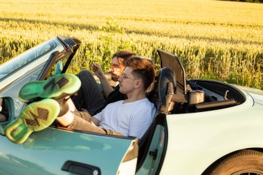 Beyaz mankenler, erkekler arabada konuşuyor.