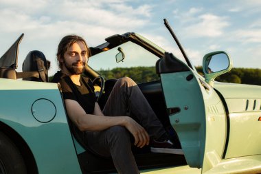 Arabada arkasında gökyüzü olan beyaz Avrupalı model adam