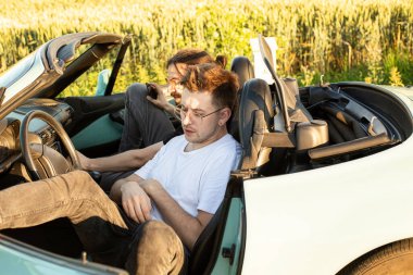 Beyaz Avrupalı mankenler arabada oturuyor.