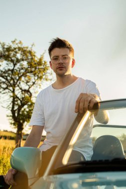 Genç beyaz Avrupalı model çocuk arabanın yanında oturuyor