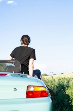 Dışarıda oturan siyah saçlı genç beyaz Avrupalı manken.