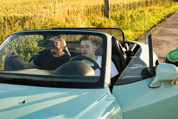 Beyaz genç mankenler arabada dinleniyor.