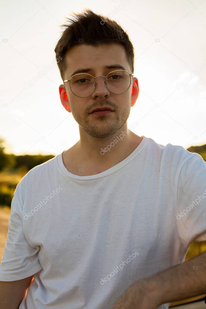 Young white european model boy outside in glasses