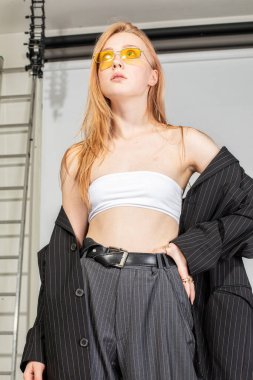 Stüdyoda ceketli kızıl saçlı beyaz kadın.