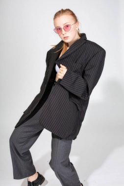 Güneş gözlüklü ve spor ceketli Avrupalı genç bir kadın griye bürünmüş.