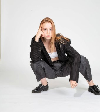 Beyaz takım elbiseli, beyaz tenli, kızıl saçlı kız.