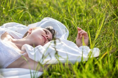 Dışarıdaki çimlerin üzerinde yatan beyaz bir manken.