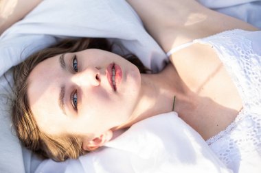 Beyaz çarşaflarda beyaz genç kız portresi