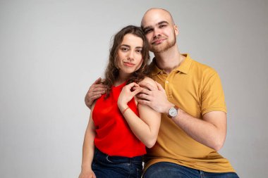 Genç beyaz Avrupalı çift, gri kucaklaşmada soyutlandı