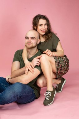 Mutlu beyaz çift pembe üzerinde yalnız oturuyor.