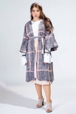 Dolgun dudaklı, kahverengi saçlı, açık gri tenli genç bir kadın.