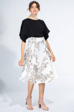 Ciddi beyaz Avrupalı kadın açık gri üzerinde tek başına duruyor