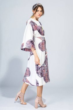 Ciddi beyaz Avrupalı kız, açık gri üzerinde soyutlanmış, dümdüz görünüyor.