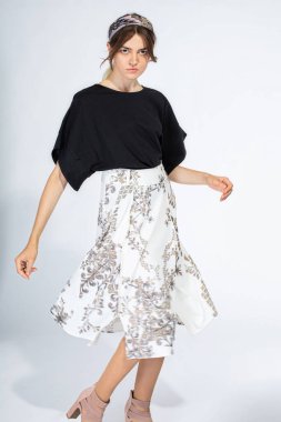 Dans eden Avrupalı beyaz kadın açık gri üzerinde tek başına duruyor