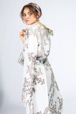 Açık gri üzerinde kahverengi saçlı Avrupalı genç bir kadın.